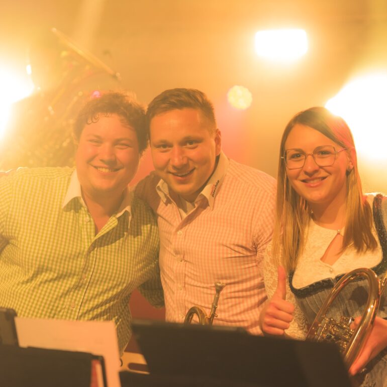 Gruppenfoto von 3 Personen auf der Bühne